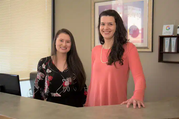 Friendly front desk reception team welcoming patients at Vital Mill Creek Chiropractic